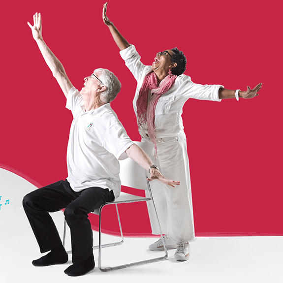 Two older adults dance enthusiastically beside each other